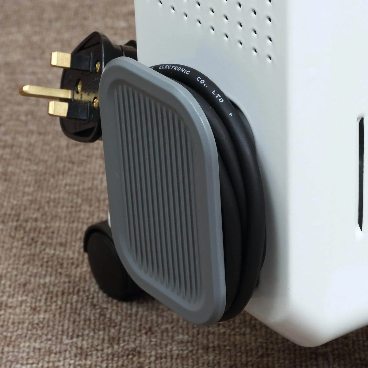 White electric heater with gray carry handle and power plug on cord