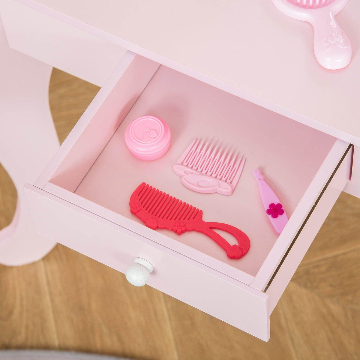 Inside vanity drawer tray with pink and red toy hairbrushes and comb set