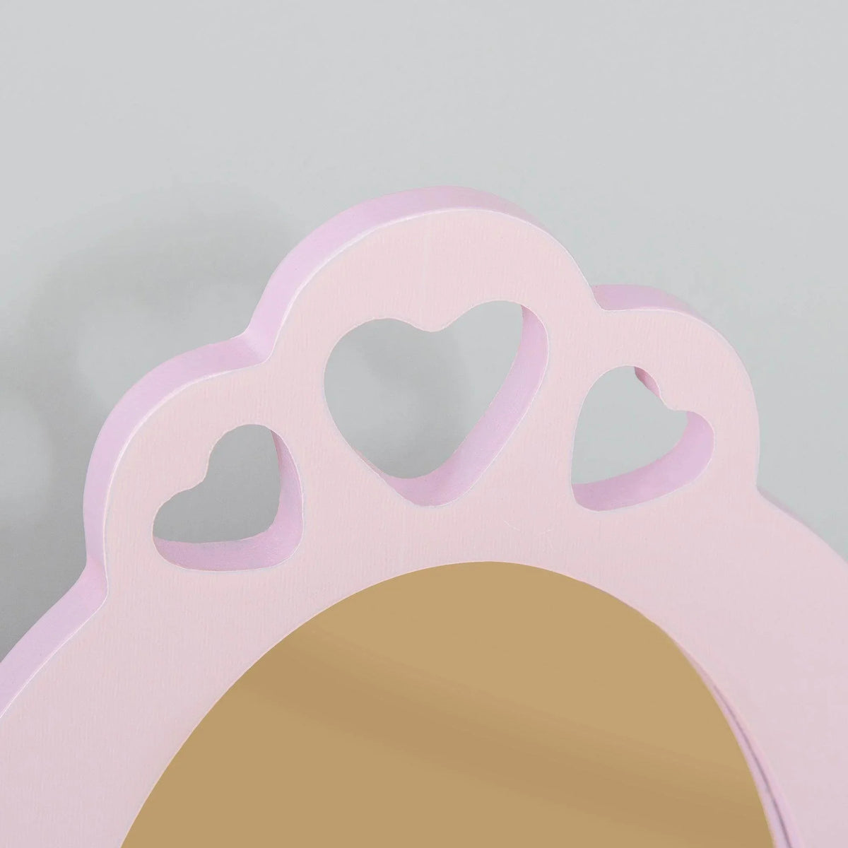 Close-up of pink arched vanity mirror frame with heart cutouts