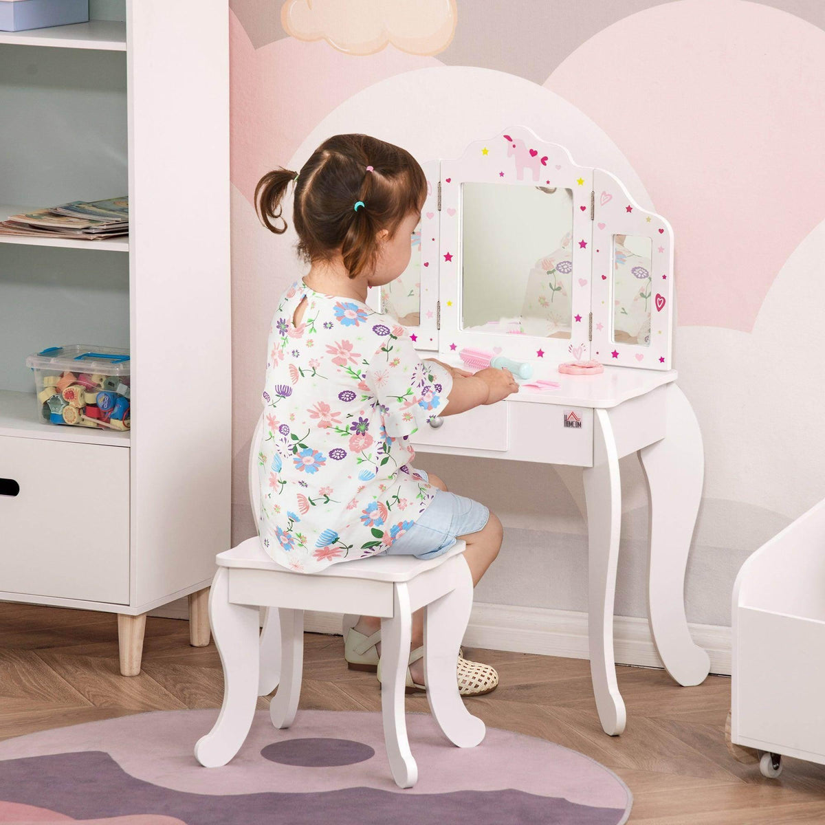 Kids vanity table set with rotating mirrors and matching white stool, child seated