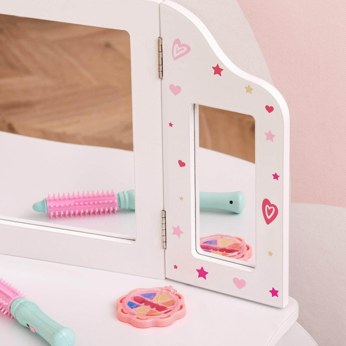 White vanity table mirror door with heart and star decals, toys on shelf
