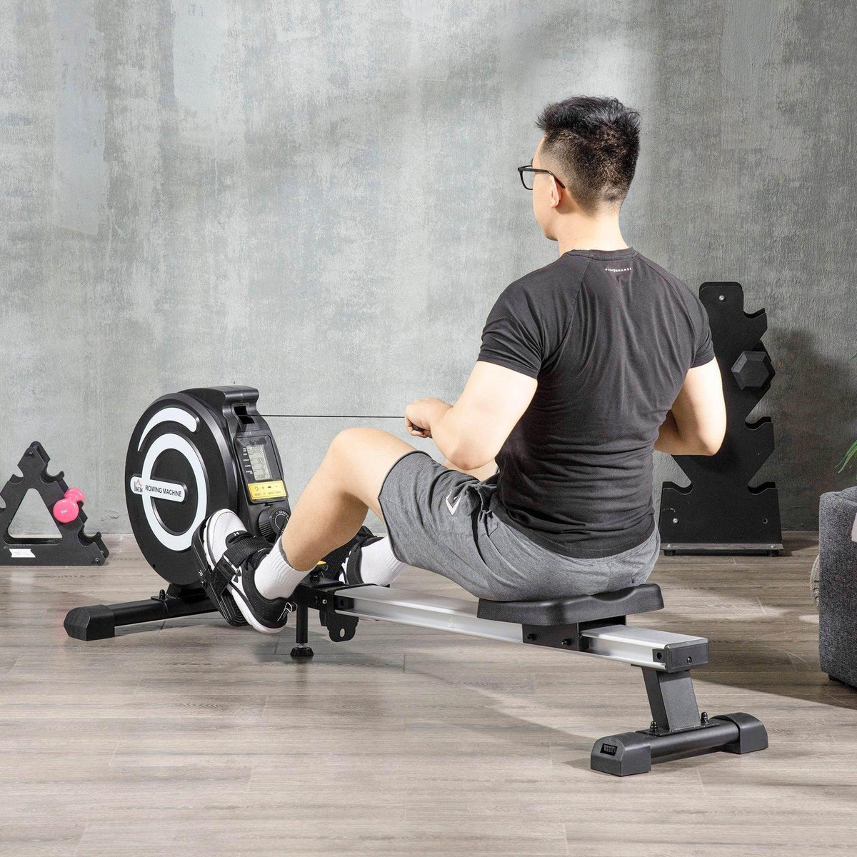 Magnetic rowing machine with padded seat, foot pedals, and handlebar for home workouts