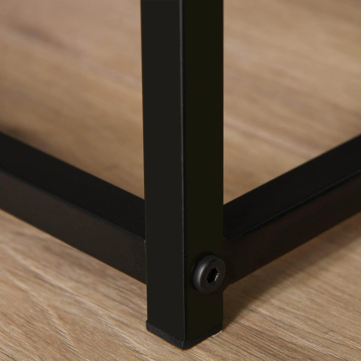 Black metal base leg detail with leveling foot under a white bedside cabinet