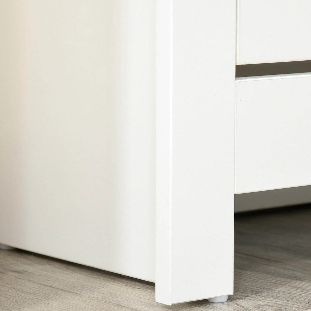 White shoe cabinet base corner with straight legs and smooth side panel.