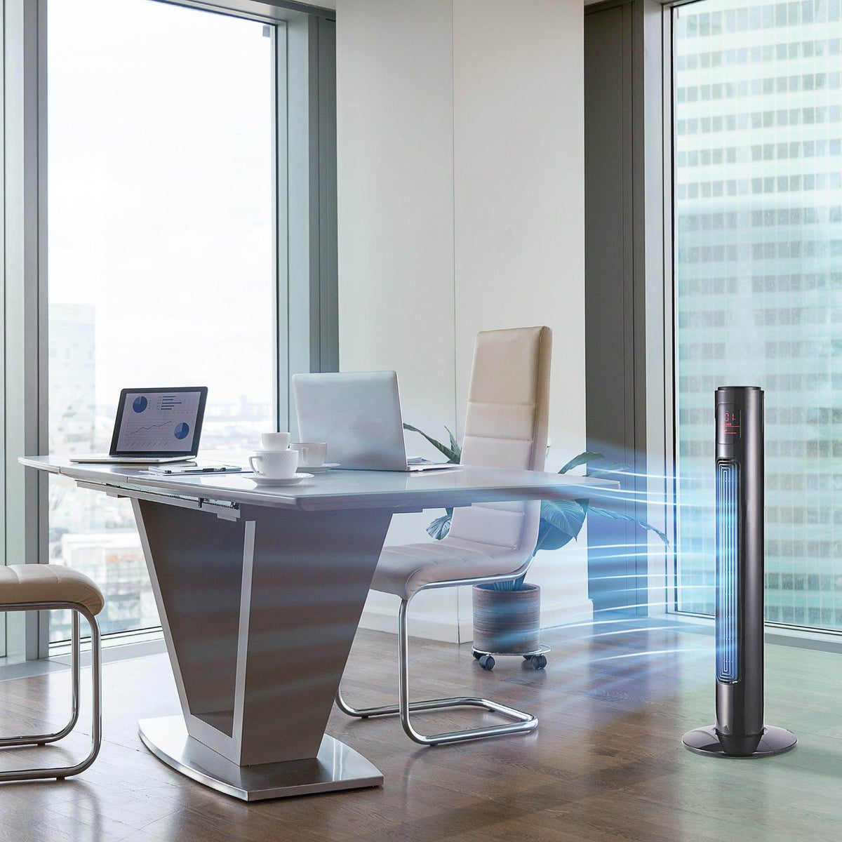 Black tower fan standing on floor with vertical grille near office desk