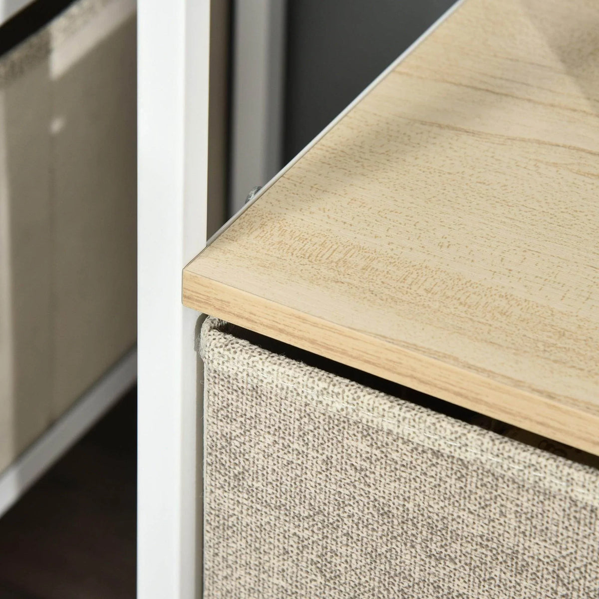 Wood top edge over gray fabric drawer front with white frame