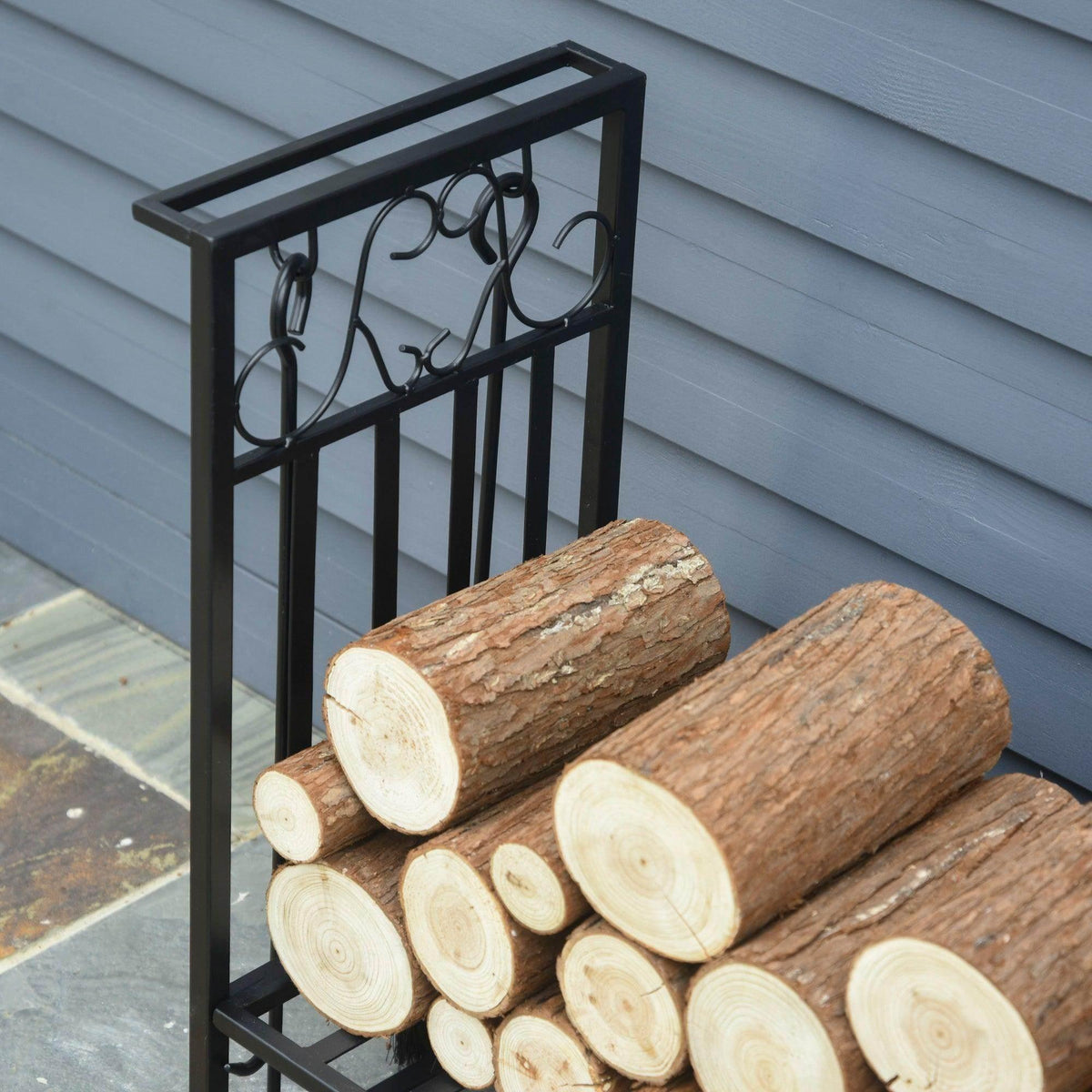 Firewood log rack filled with stacked cut logs against the front grille frame.