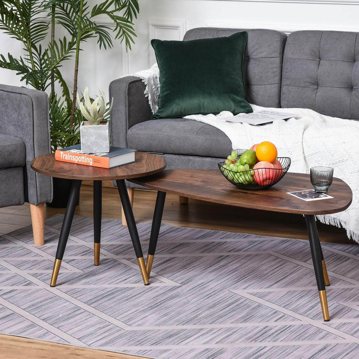 Round nesting coffee table with dark wood top, black legs, and gold accent tips