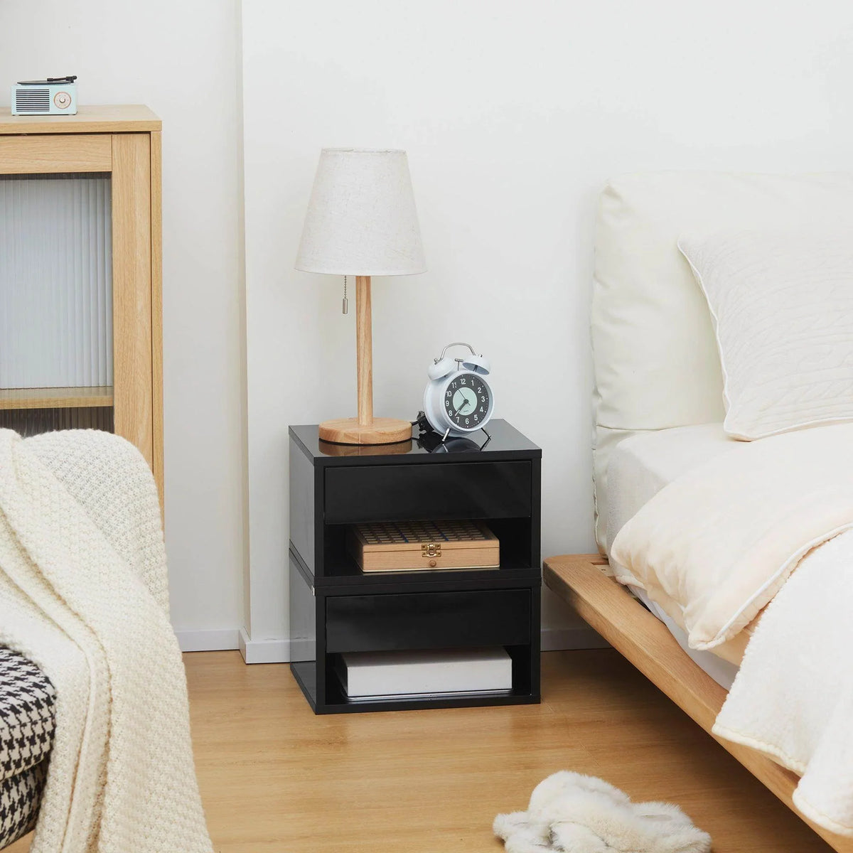 Glossy black wall-mounted bedside table with drawer and open shelf, front view
