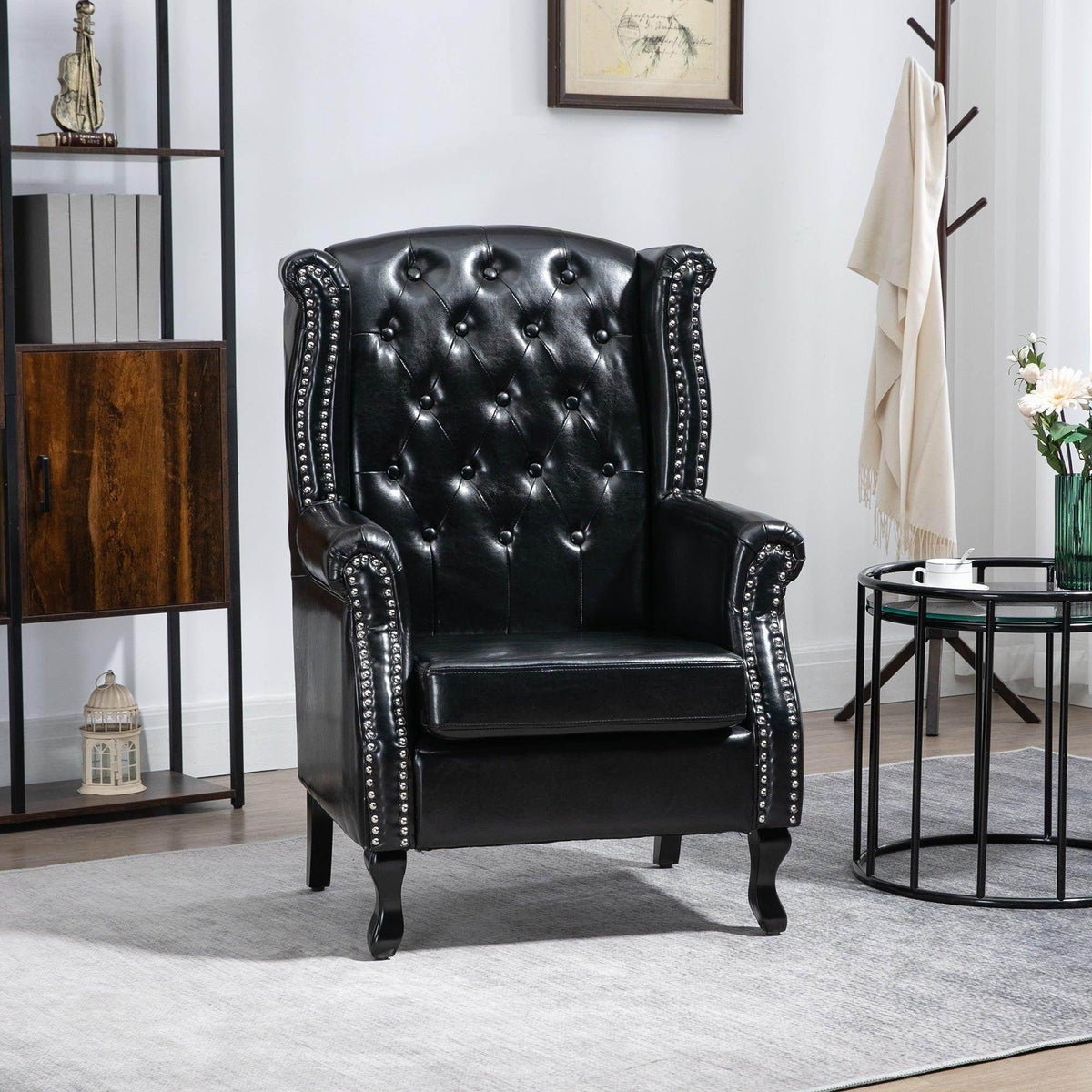 Black tufted wingback armchair with studded nailhead trim and rolled armrests