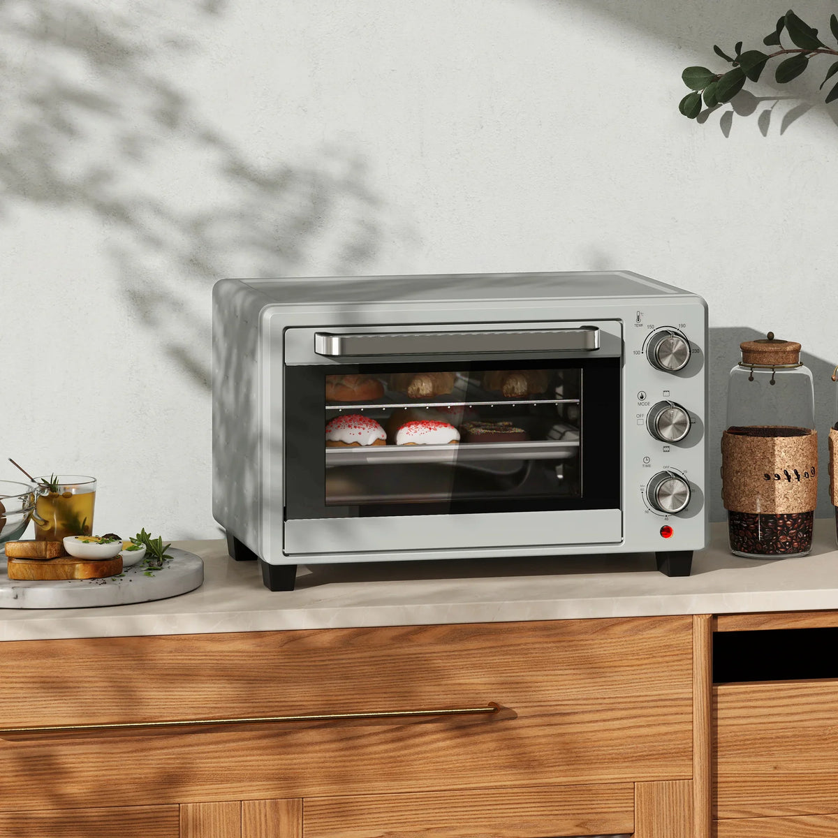Silver mini countertop oven with glass door and control knobs, front view