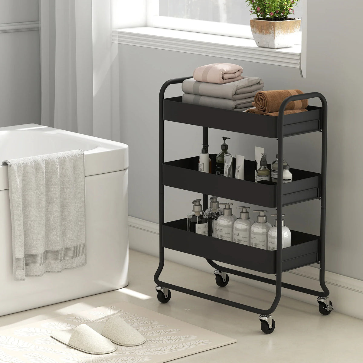 Black rolling storage trolley with three mesh shelves for toiletries and folded towels