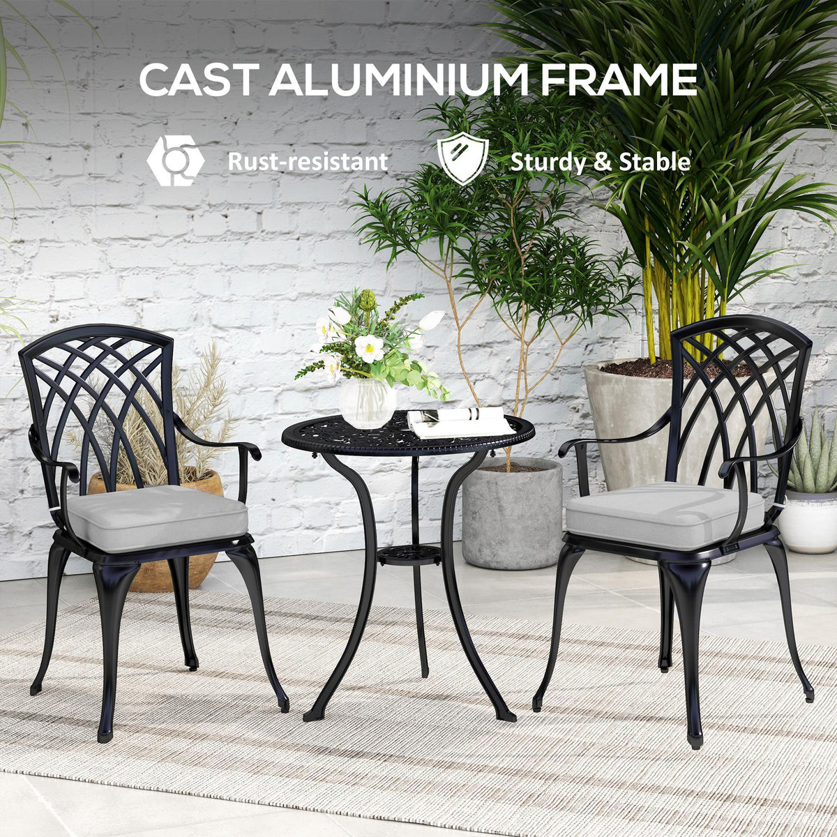 Black cast-aluminum bistro set with two cushioned armchairs and round umbrella-hole table