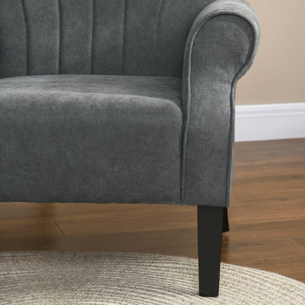 Close-up of grey rolled arm and cushioned seat on high-back accent chair