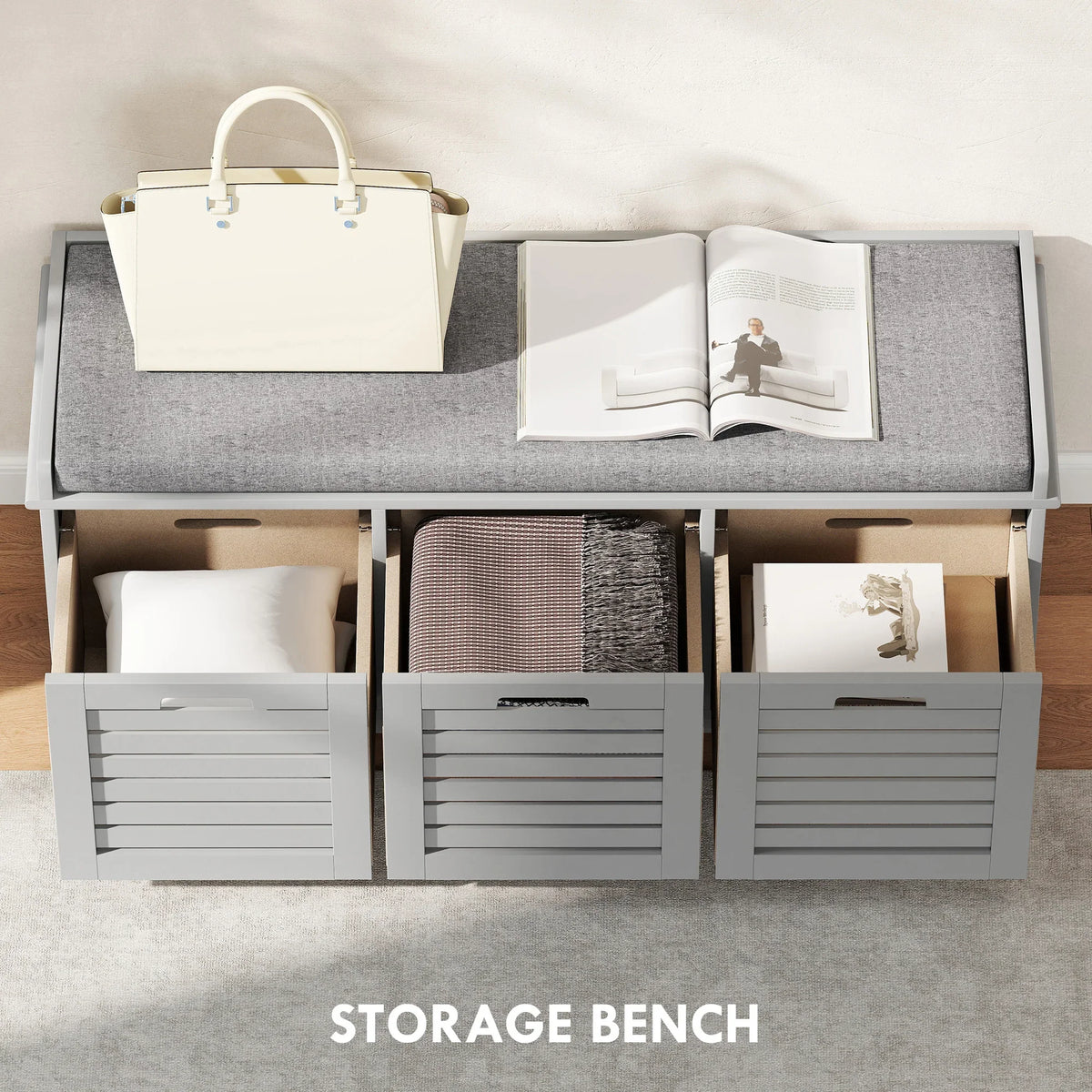 Grey shoe storage bench with cushioned top and three open storage sections