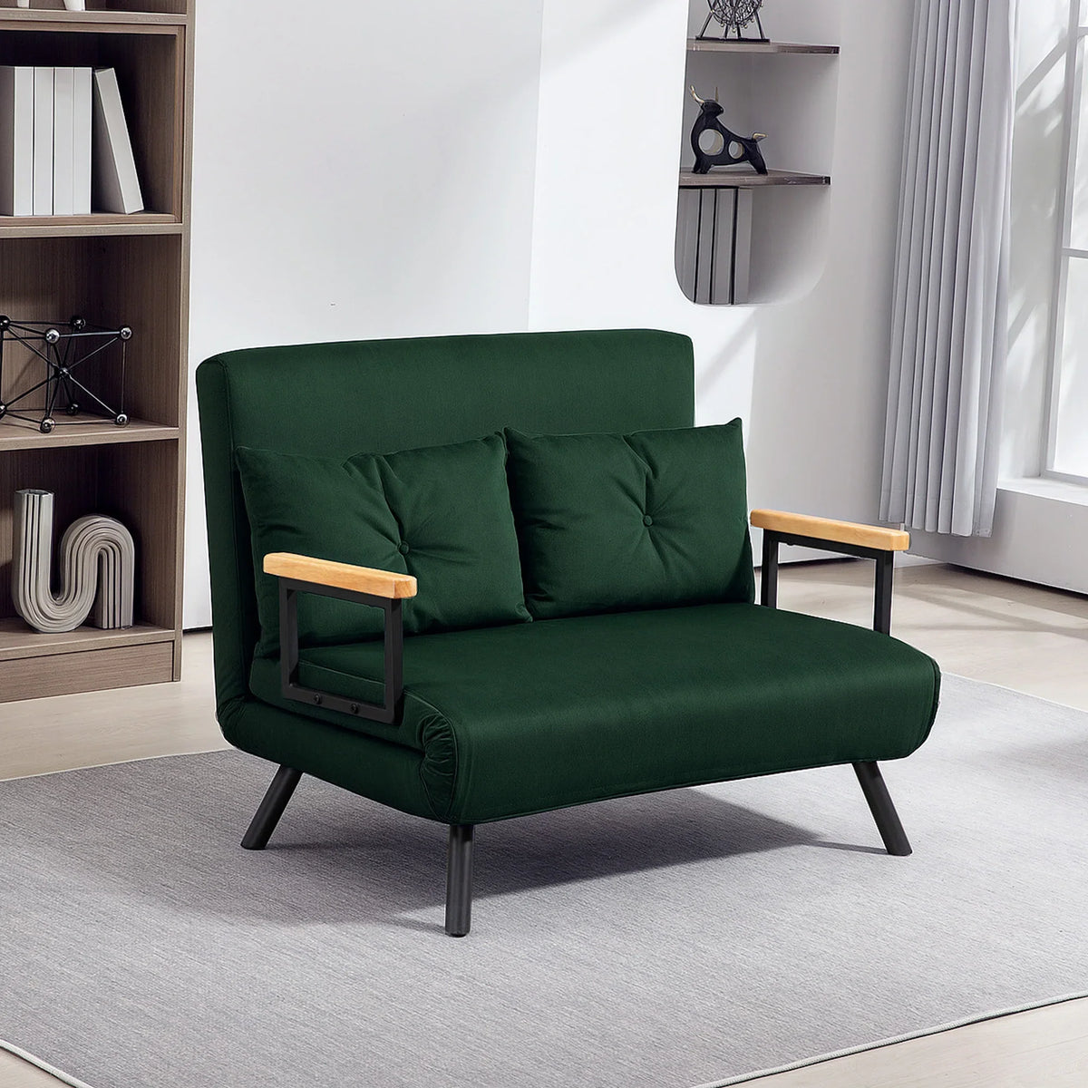 Green velvet-feel sofa bed with two tufted back pillows and wooden armrests