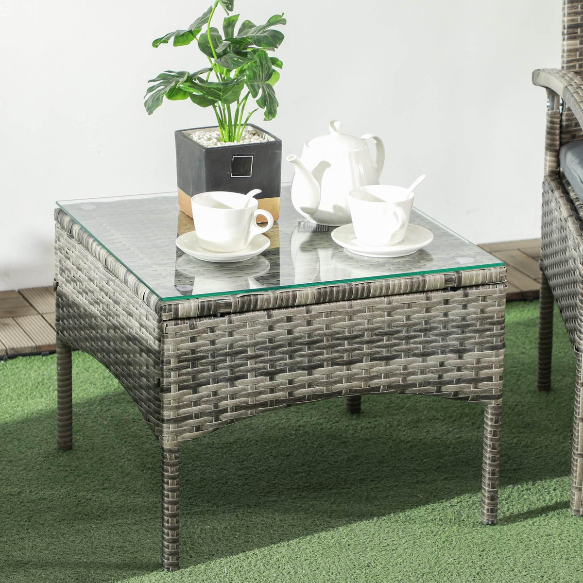 Square grey rattan coffee table with clear glass top and teal edge trim