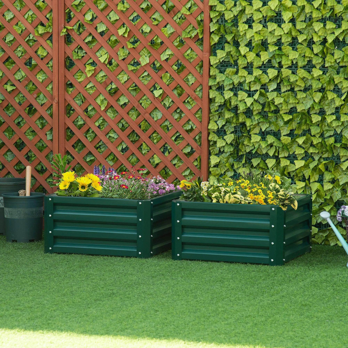 Set of 2 green raised garden planter boxes with slatted sides, outdoors with flowers