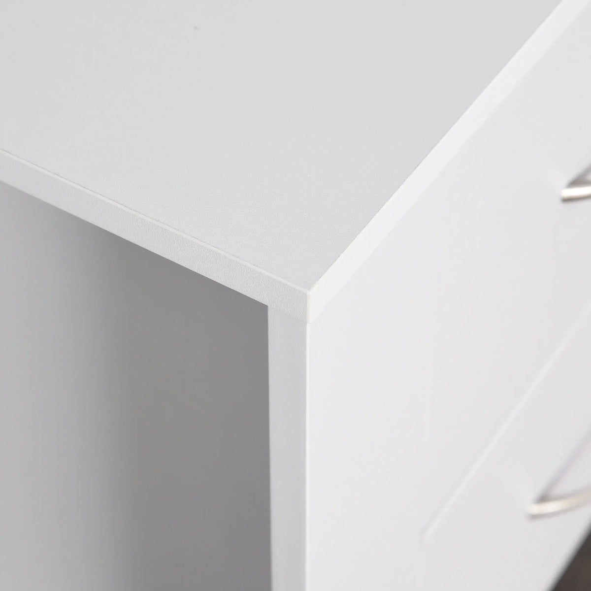 White bedside table corner and top edge with smooth finish and partial drawer handle
