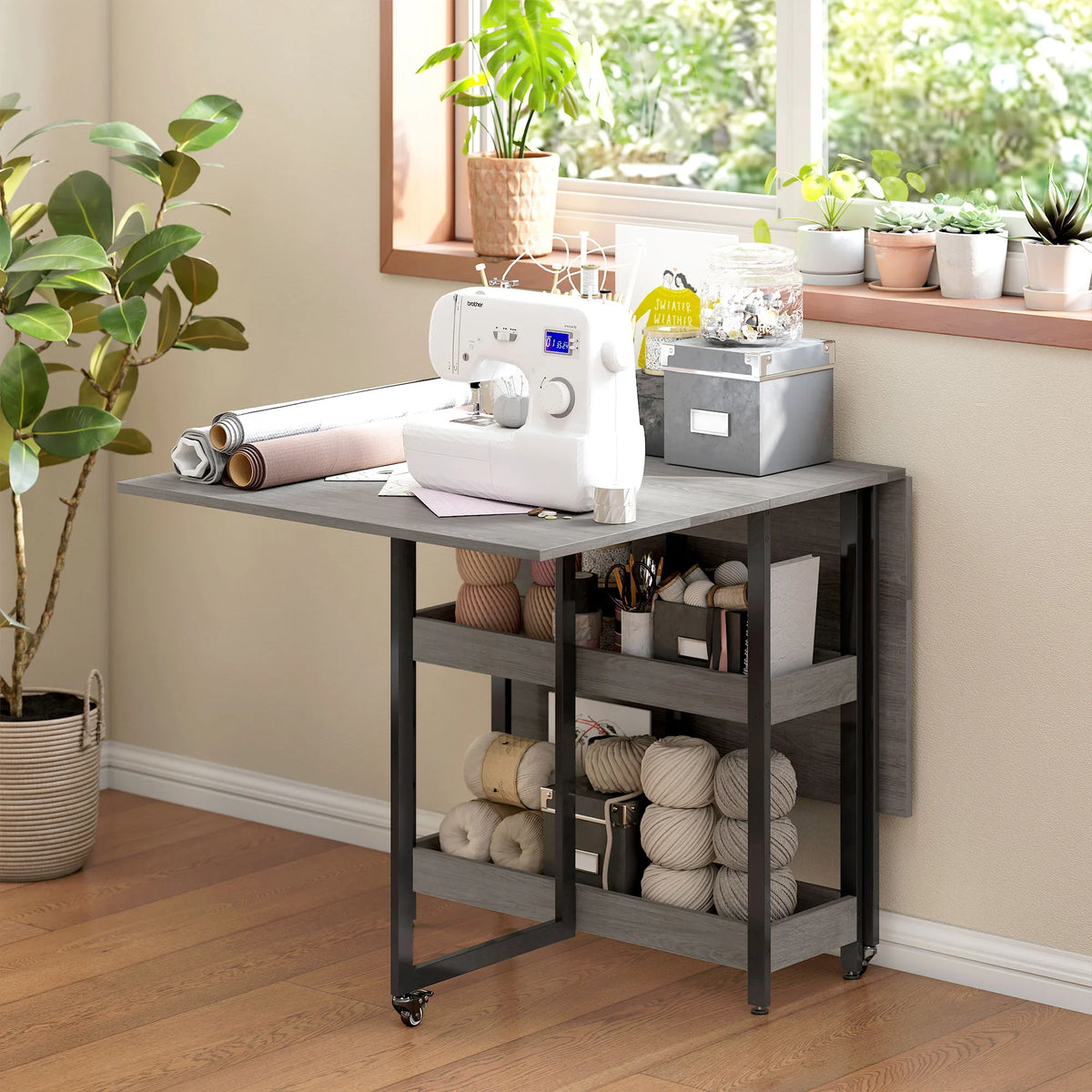 Grey wood-effect drop-leaf dining table with lower shelf and black metal legs on casters