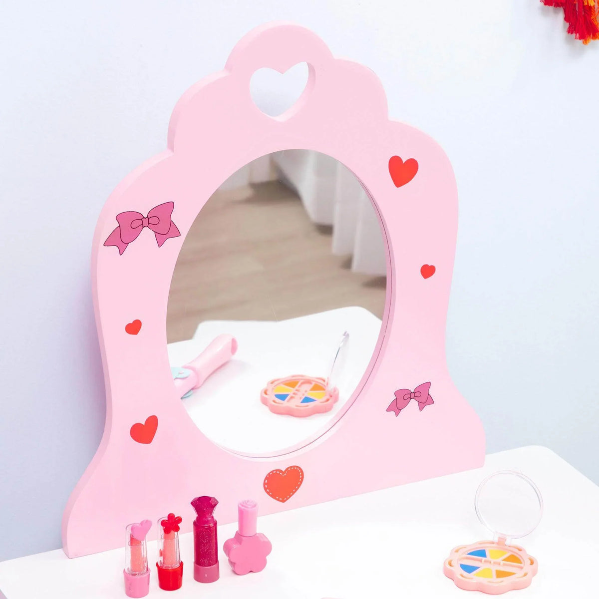 Pink heart-shaped mirror panel on kids playhouse bed with toys in front