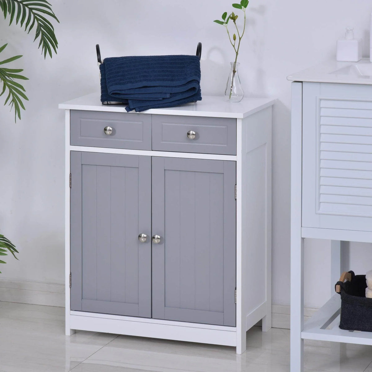 Grey freestanding bathroom cabinet with two drawers, two-door base and round metal knobs.