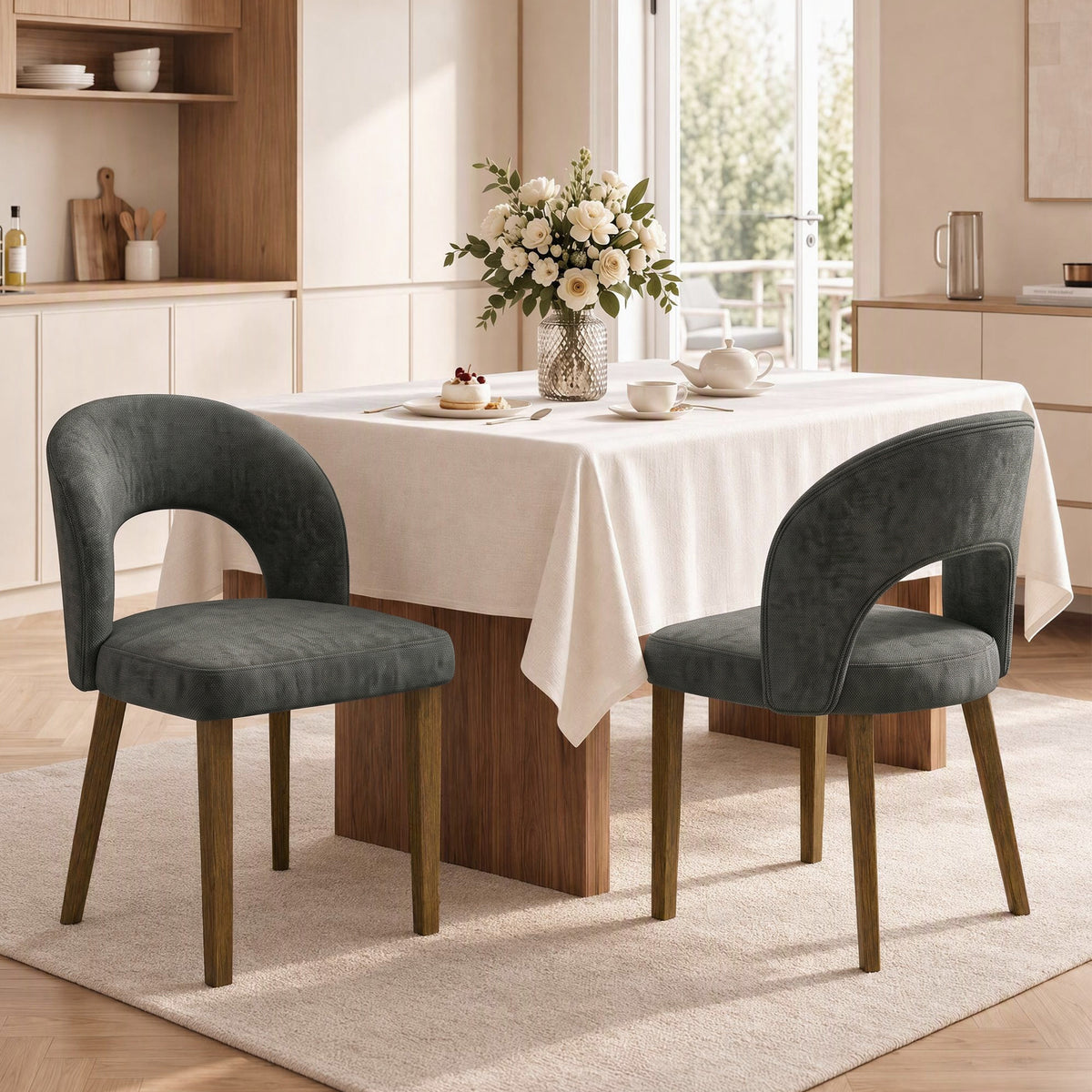 Set of 2 dark grey upholstered dining chairs with arched backs and wooden legs