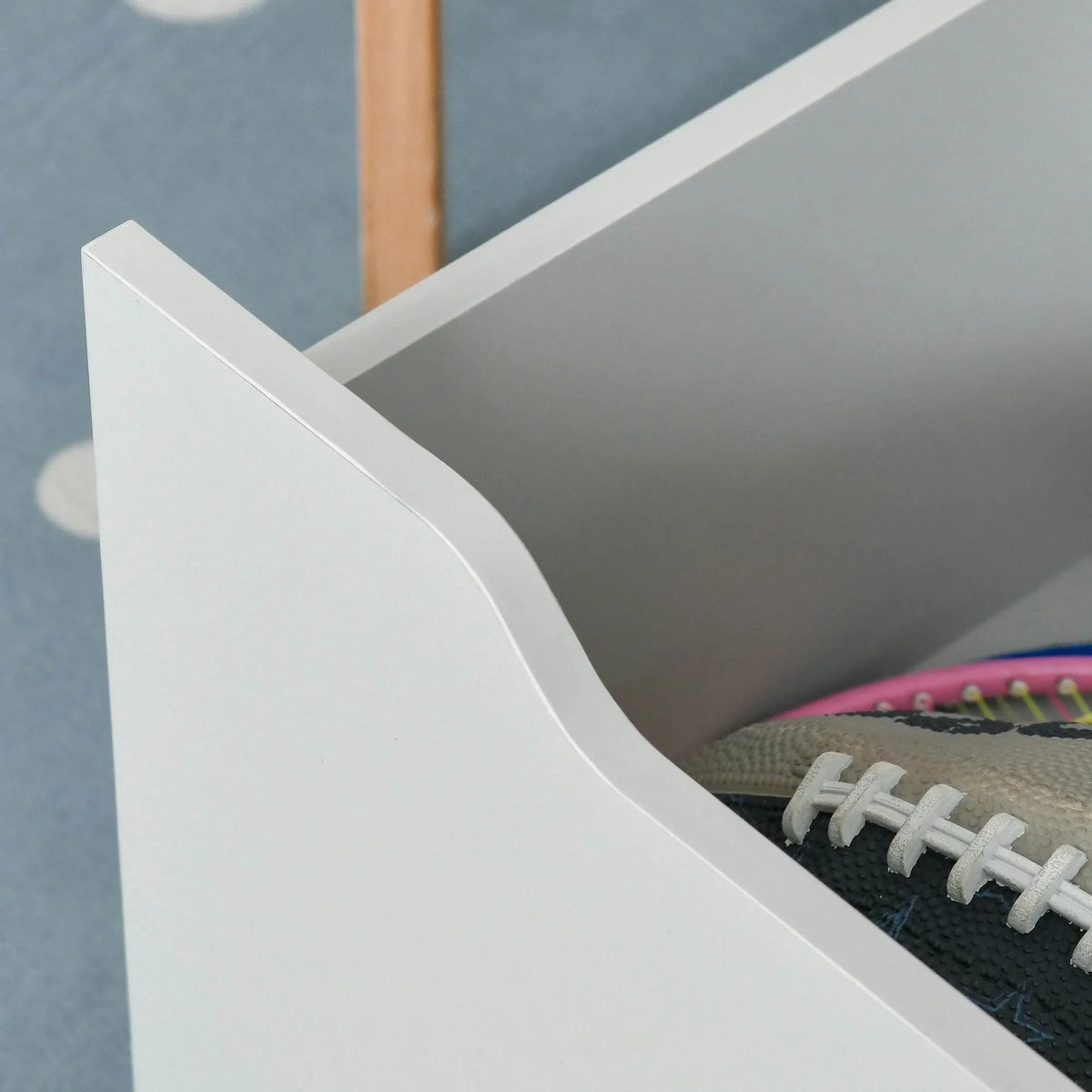 Grey kids bookcase corner with rounded edge and open storage compartment, close-up
