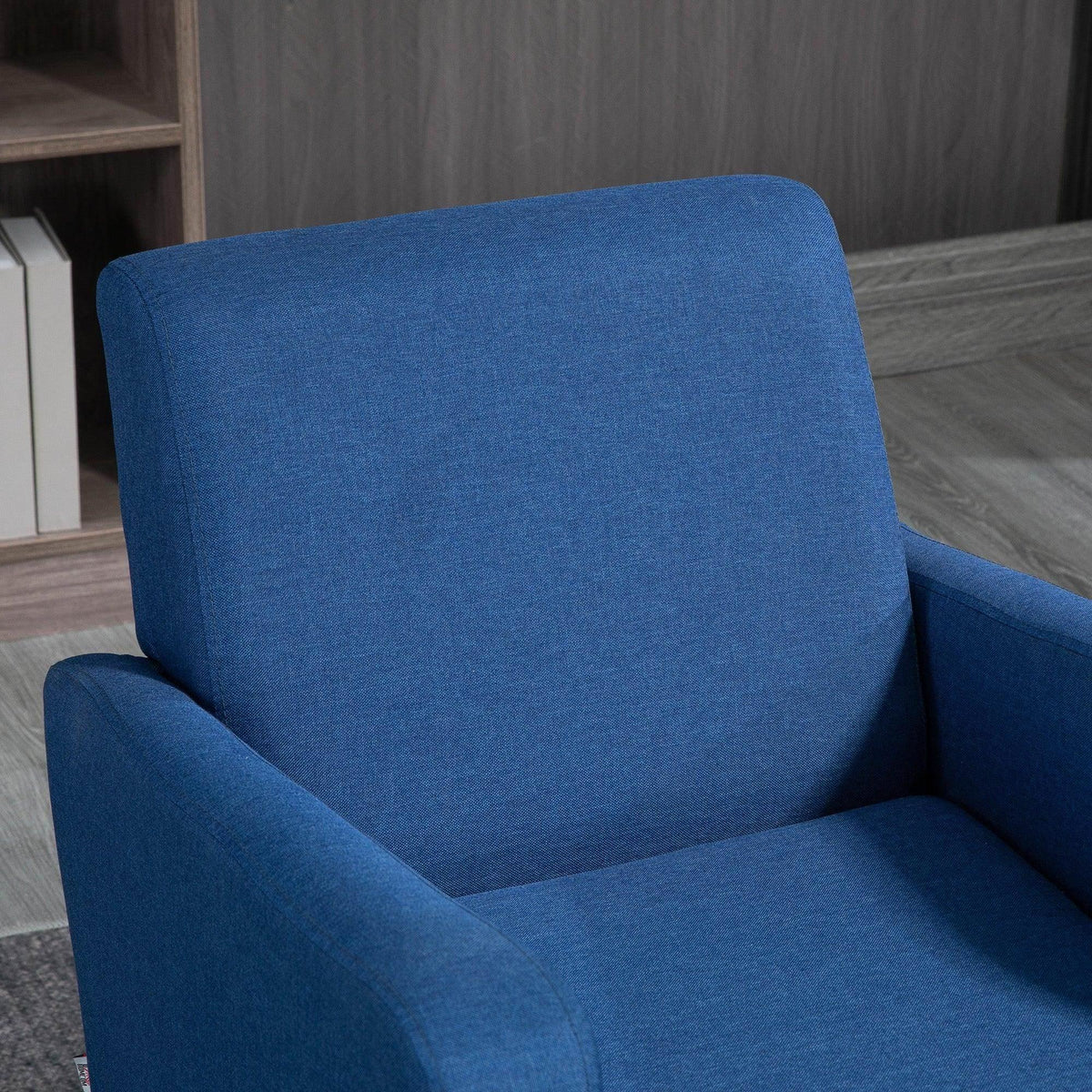 Blue upholstered armchair with high back and thick, padded seat cushion.
