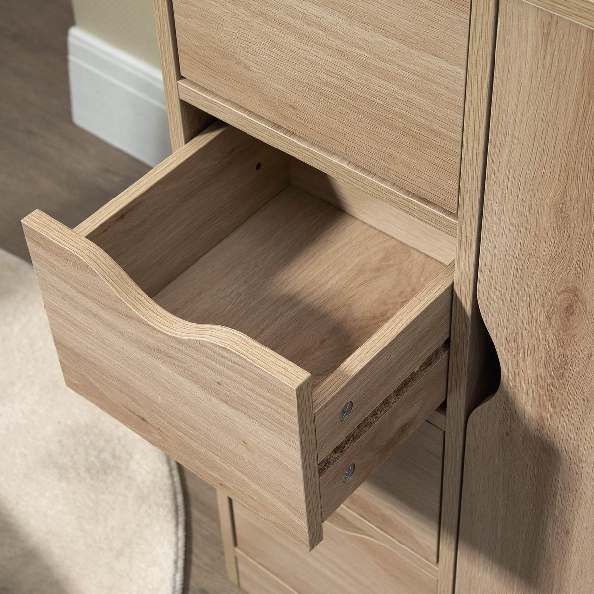 Open drawer inside natural wood bathroom storage cabinet with cutout handle