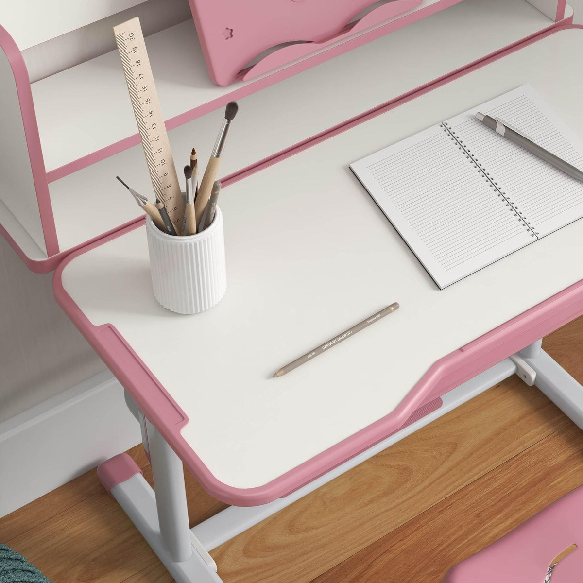 Pink kids study desk with ruler and pencils on the desktop, plus book shelf