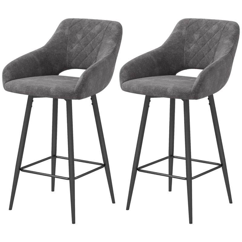 Set of 2 grey upholstered bar stools with backs and black metal footrests.