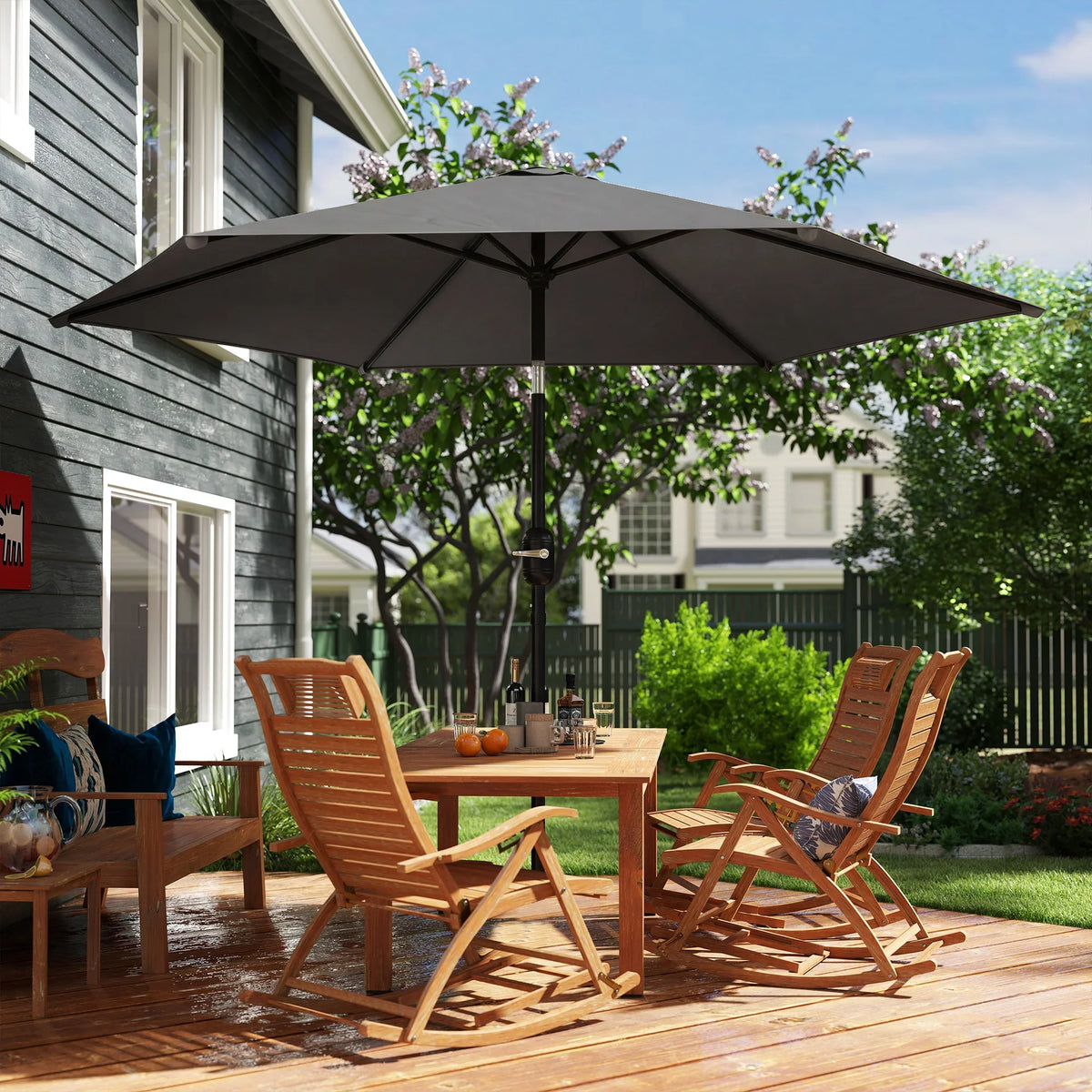 Black outdoor patio parasol umbrella shading a wooden deck seating set
