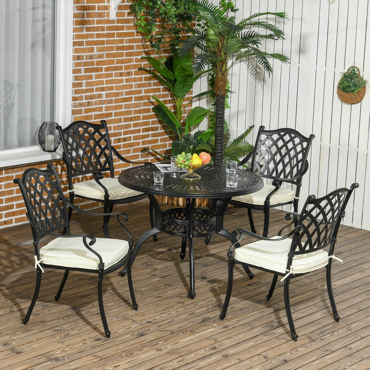 4-seat outdoor dining set with black cast-aluminum table, chairs, and cream cushions