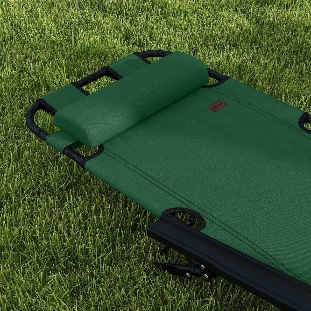 Green folding sun lounger reclined on grass with padded headrest