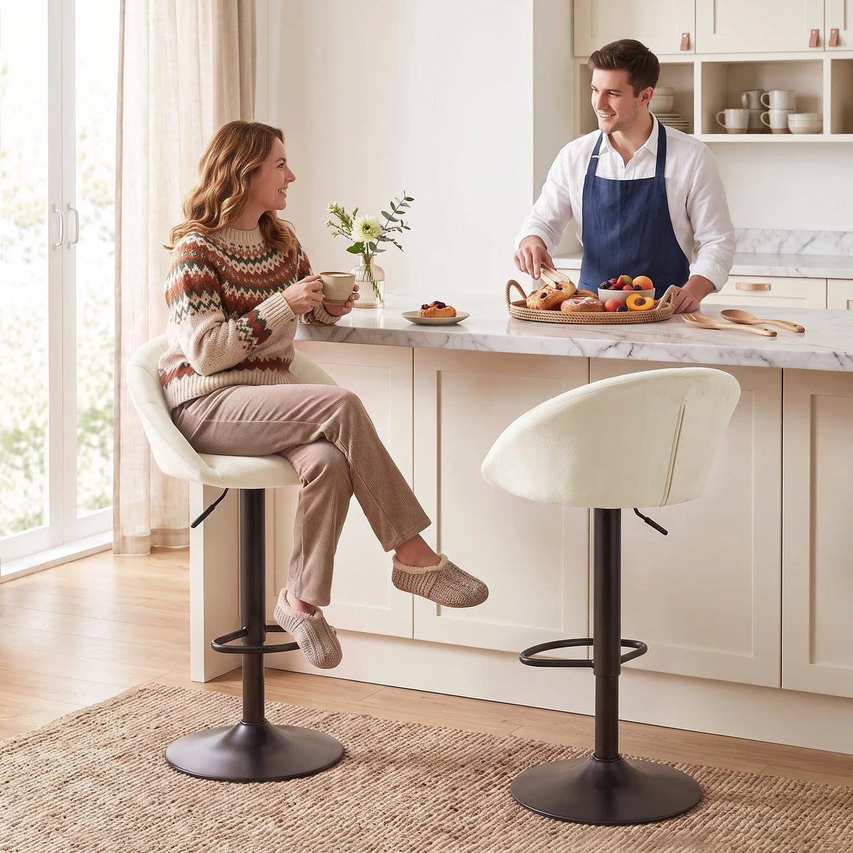 Set of two cream upholstered bar stools with padded backs, swivel bases, and footrests