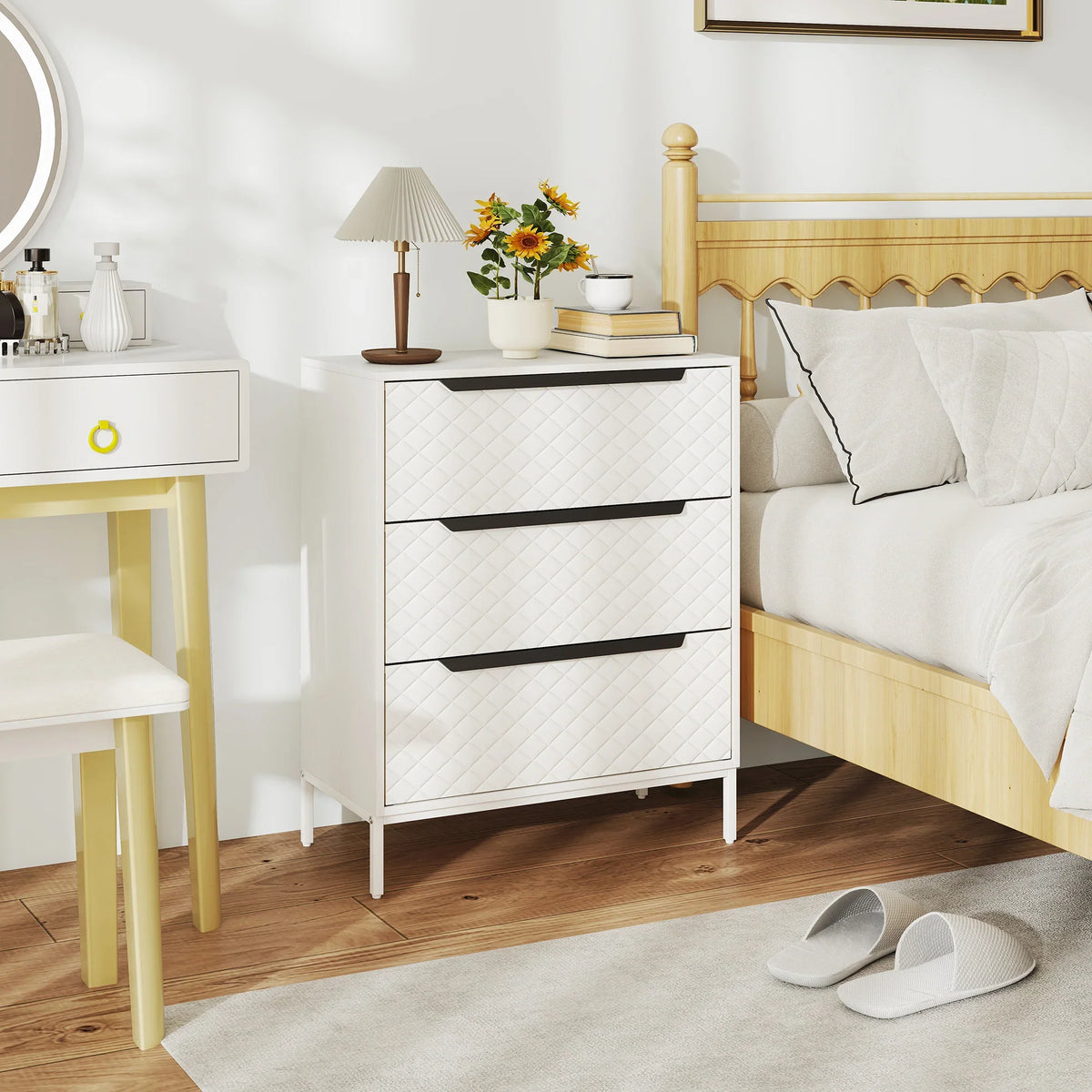 White fabric chest of drawers with quilted front, dark metal handles, and slender legs