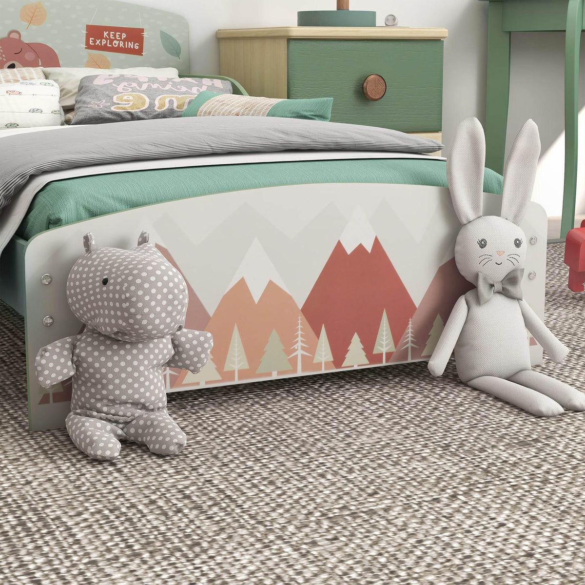 Green kids bed with mountain print panel and plush bunny and bear dolls