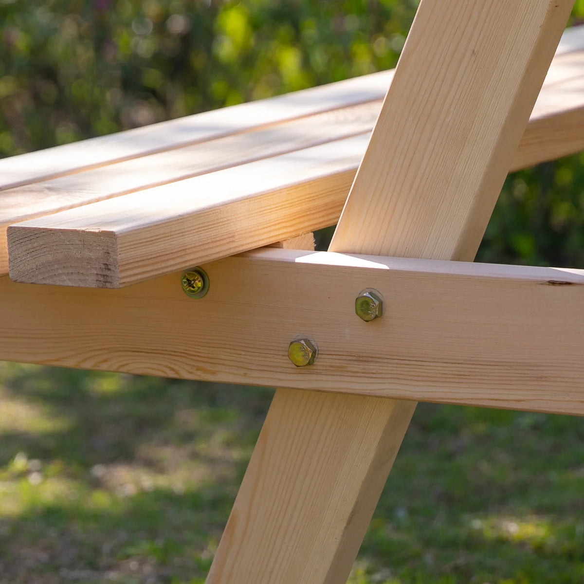 Close-up of natural wood table joint with screws at the cross support