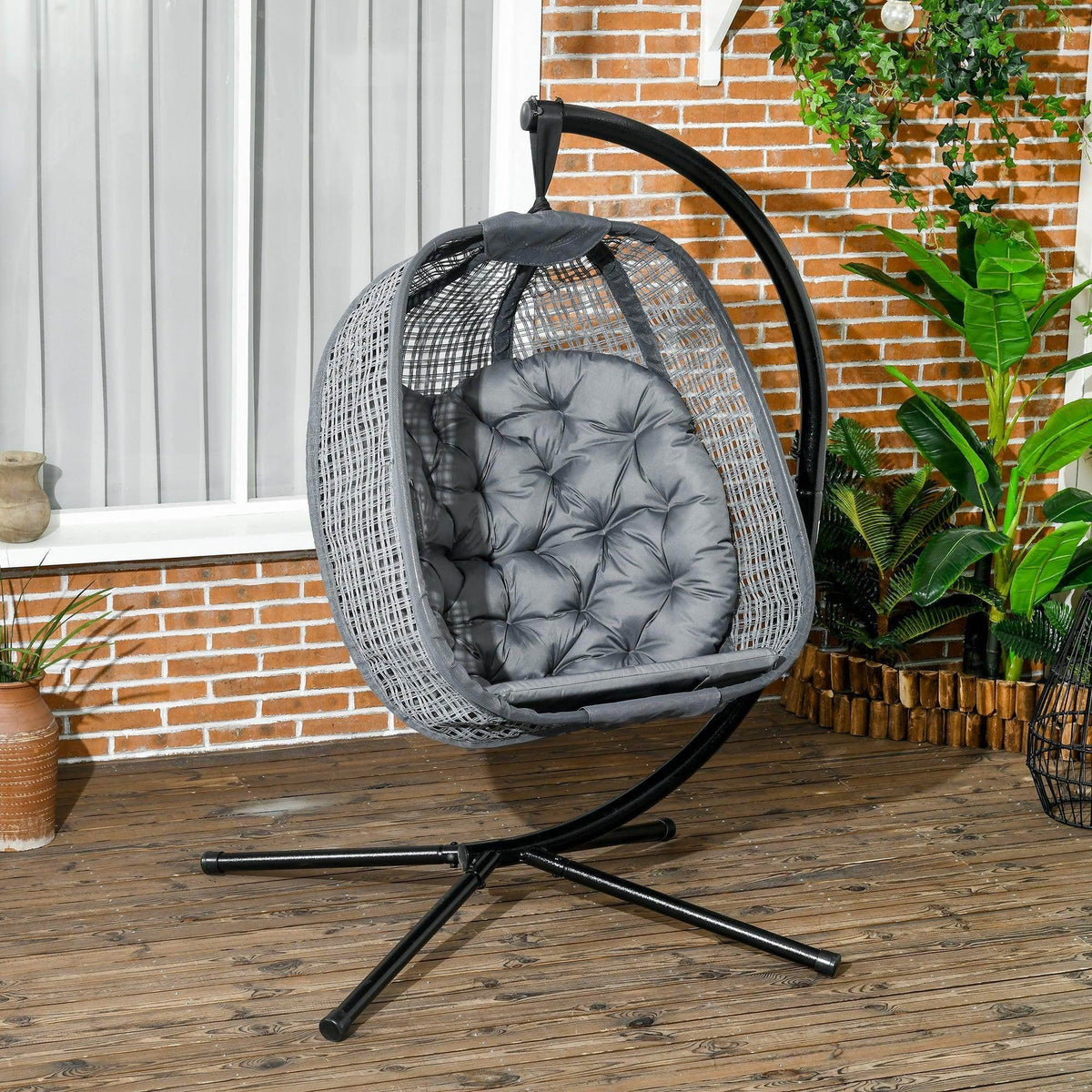 Outdoor hanging swing chair with dark grey padded cushion and curved metal base stand