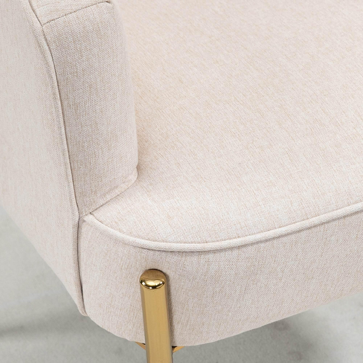 Cream upholstered armchair armrest and side panel with gold metal leg