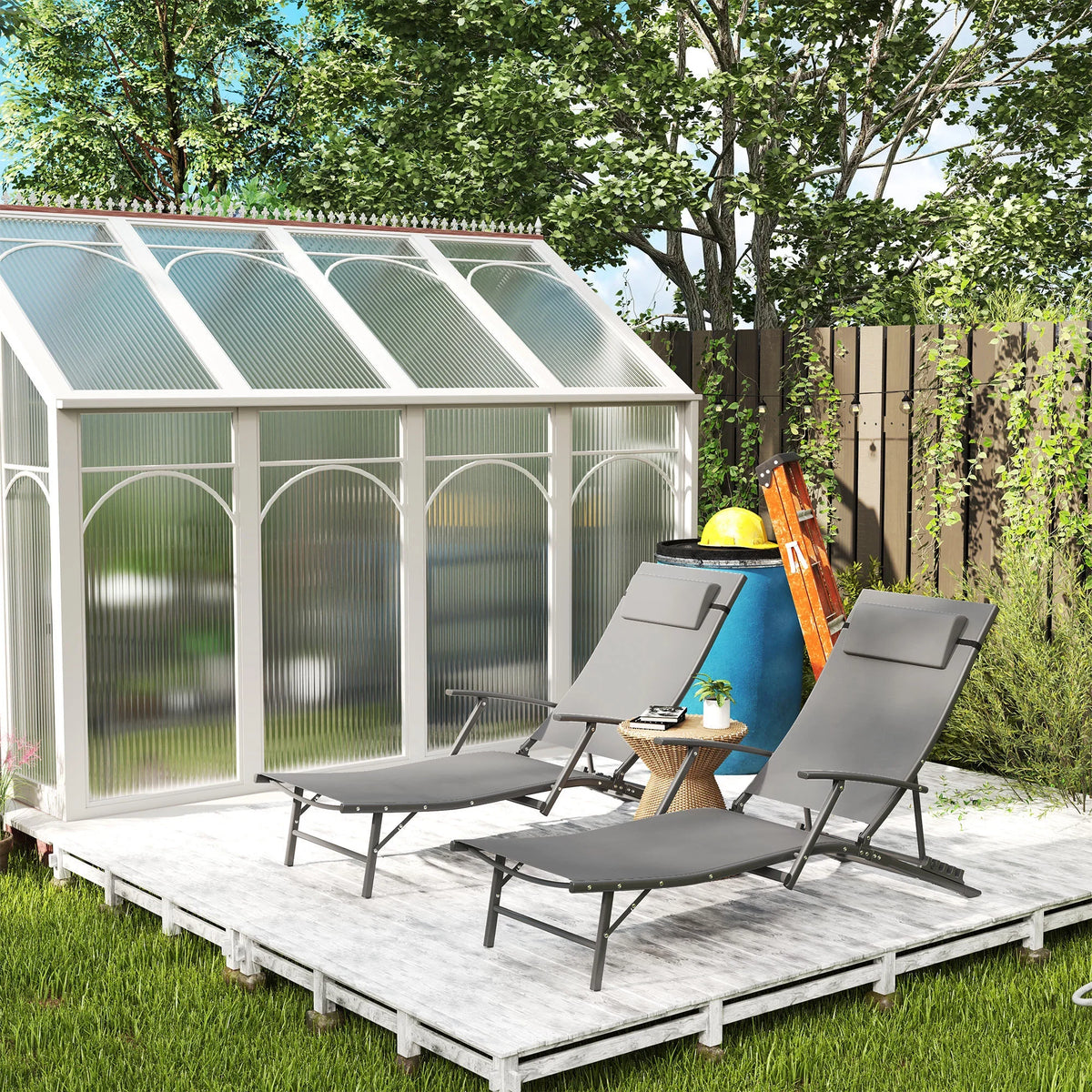 Grey adjustable back sun loungers set of two on outdoor patio with trees and fence