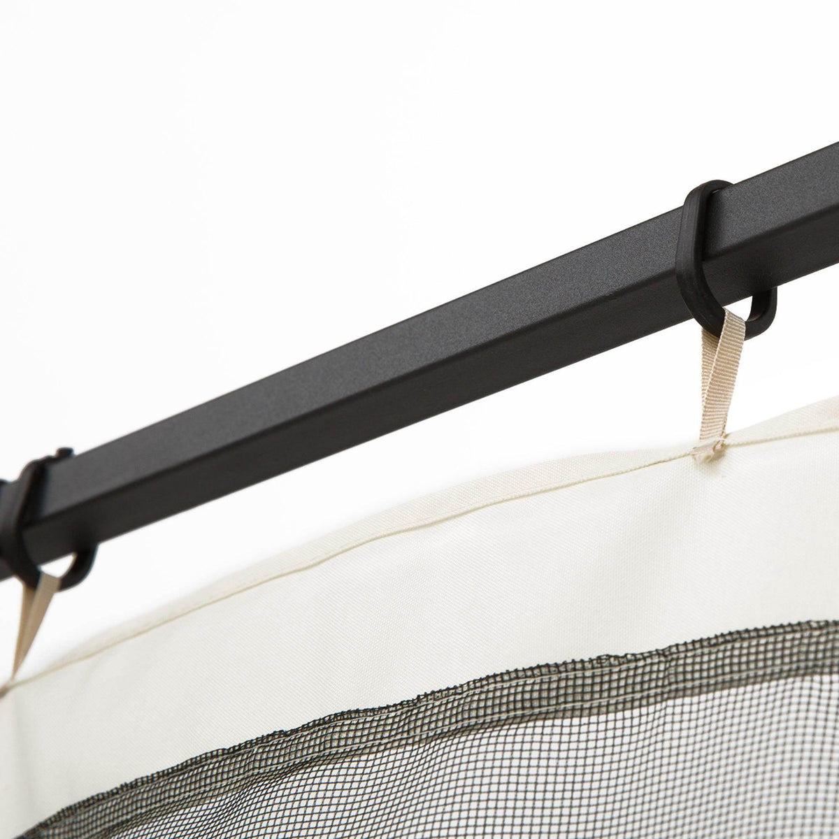 Mesh gazebo sidewall hanging from a black top bar with fabric tabs