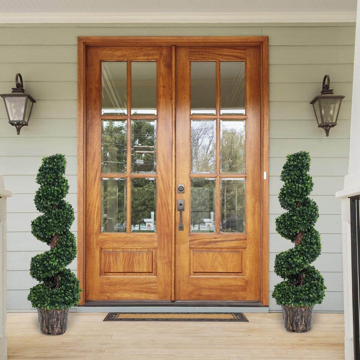 Artificial boxwood spiral topiary trees, two in dark ribbed pots with dense green foliage