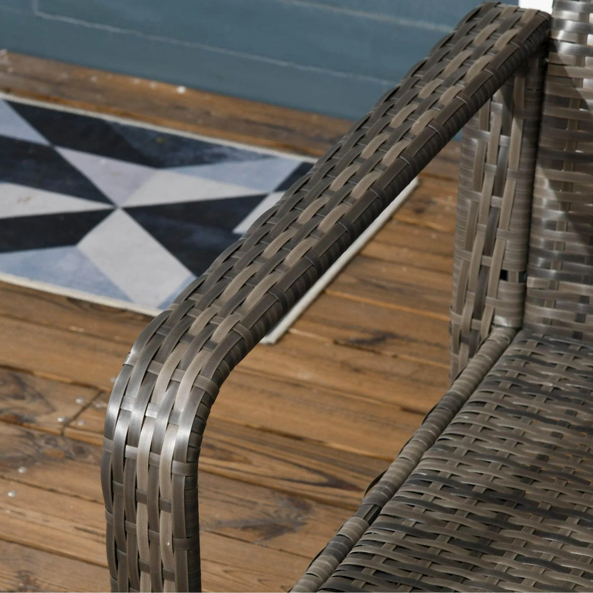 Close-up of grey rattan wicker armrest with tight woven pattern on patio chair