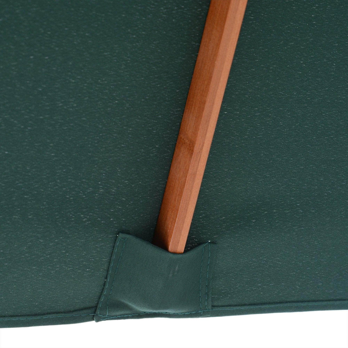 Dark green patio umbrella canopy corner with brown wooden pole base seam