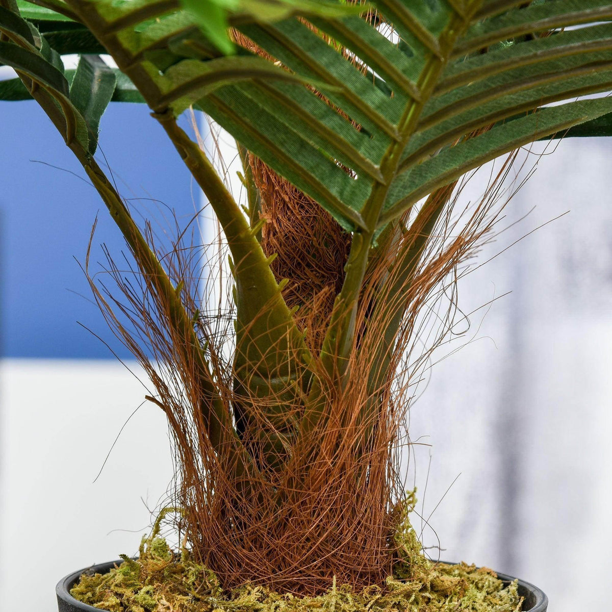 Artificial palm trunk with dried fibers and green fronds, in black pot