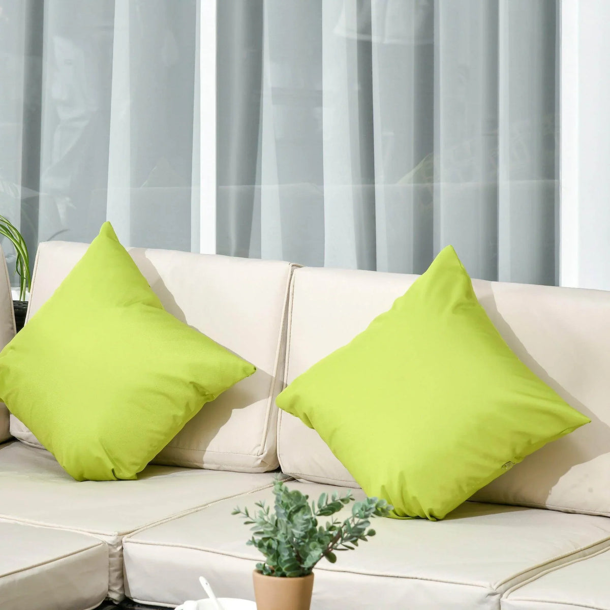 White outdoor sofa cushions with bright lime green throw pillows