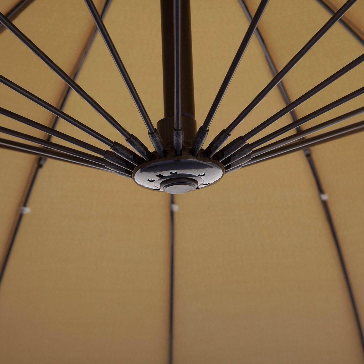 Beige umbrella canopy underside with metal rib hub and support ribs.
