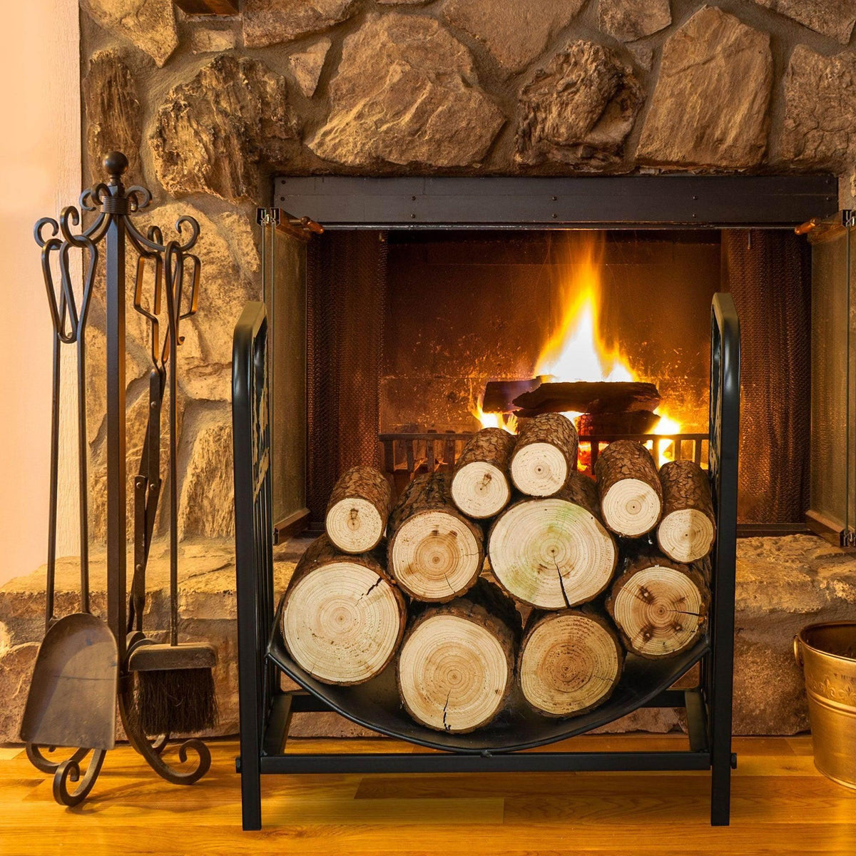 Black metal log rack with front curved panel holding stacked firewood logs and cutouts.